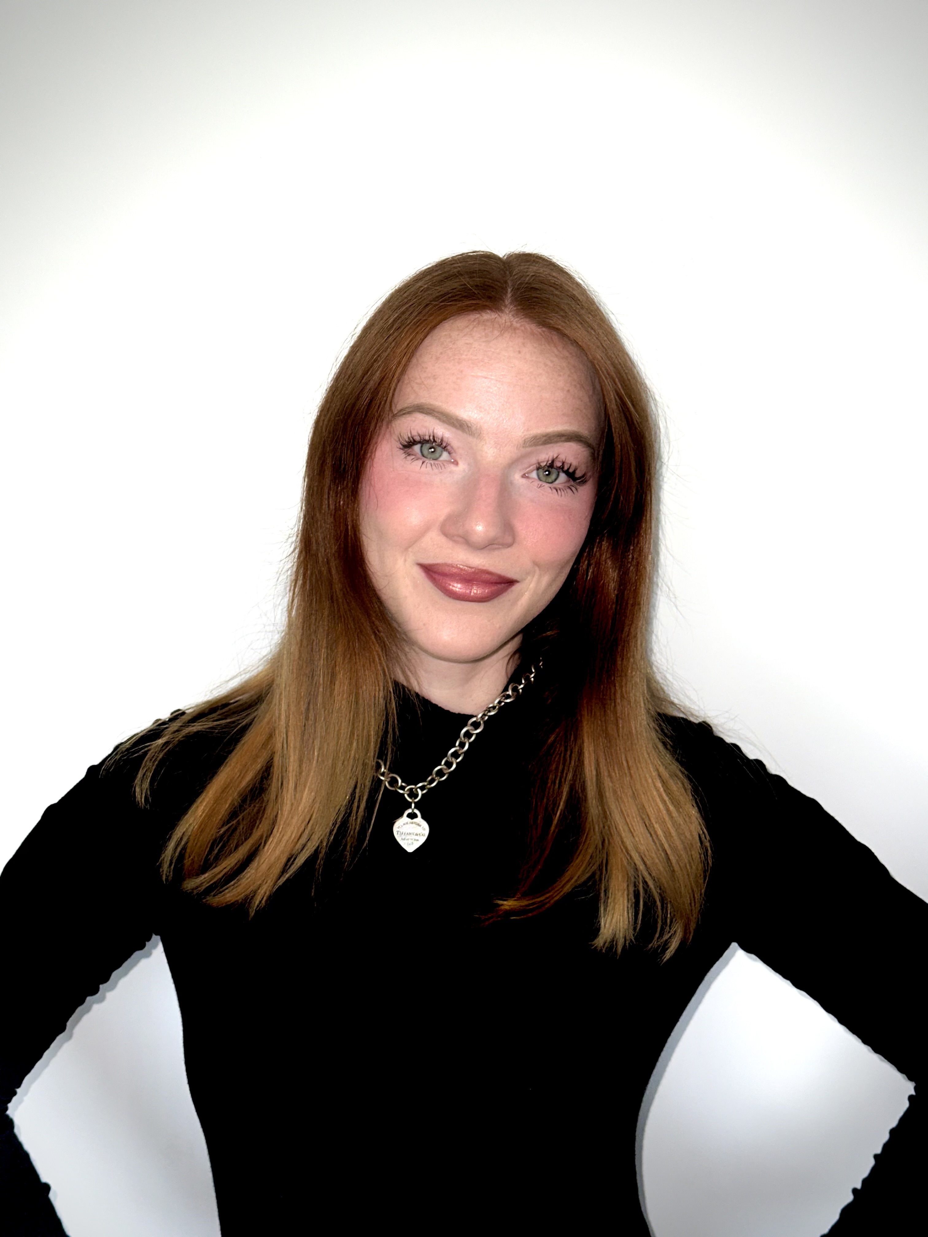 Sabrina Sparks smiling in a black top with her hands on her hips